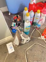 Overview showing Rowenta iron, spray starch cans, detergent jugs, thread spools