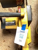 Left side view of yellow McCulloch Electramac EM 16 ES chainsaw showing handle and lot tag