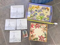 Full lot view: two trays, four Eiffel Tower plates, paper model