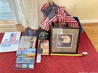 Group shot showing framed eagle print, flags in bin, and six books