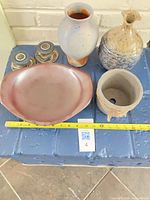 Group shot of all pottery items on surface with tape measure for scale