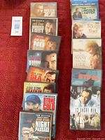 Array of DVD cases including Jesse Stone titles and assorted dramas on red surface