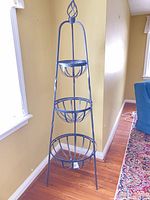 Full view of three-tier metal basket stand