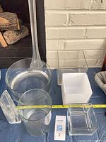 Group of vases on blue surface showing cube vases, round vases, bud vases