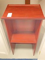 Full front view of wooden lectern showing top and shelf