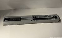 Torque wrench seated in open gray plastic case