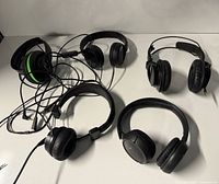 Group shot of all five headphones with visible cables