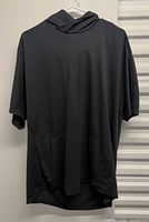Front view of black Nike short-sleeve hooded shirt hanging
