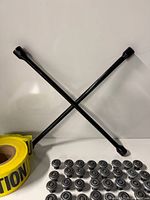 Lug wrench crossed, row of wheels, part of caution tape