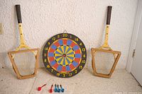 Front view of entire lot: dartboard, two Wilson rackets, six darts