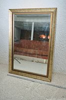 Full view of mirror front showing gold frame and glass