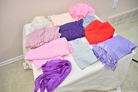 Overview of all 11 scarves and shawls laid out on table
