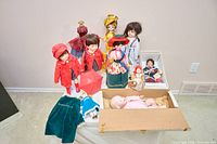 Group shot of ten assorted dolls with accessories on table