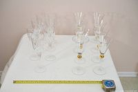 All fourteen wine glasses on table with tape measure for scale