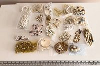 All jewelry pieces laid out in bags beside ruler for scale