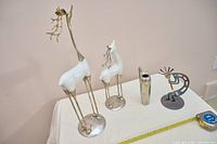 Overall view of two deer figurines, metal vase and Kokopelli sculpture