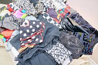 Top view of piled scarves and shawls showing variety of colors and patterns