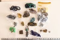 Overview of all bagged jewelry pieces laid out with ruler for scale