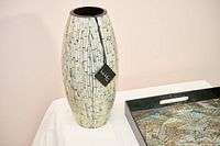 Vase with hang tag and corner of tray visible