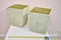 Front view of both square beige textured planters