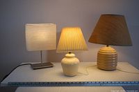 Front view of all three lamps side by side with ruler for scale