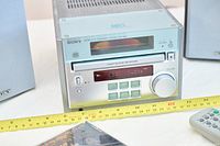 Front view of receiver with display lit, partial speakers at sides