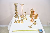 Front view of entire lot on table showing all candlesticks, angels and accessory