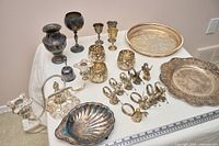 Full lot overview showing trays, goblets, vases, candelabra, napkin rings, votive holders, shell dish, bell