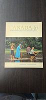 Front cover showing title Canada 67 and river scene image