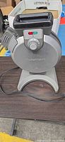 Front view of Cuisinart flip waffle maker showing stainless housing, dial and cord