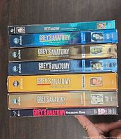 Stacked spines of seven Grey's Anatomy DVD season sets