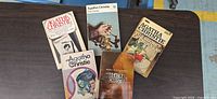 Front covers of all five Agatha Christie paperbacks displayed on table