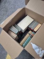 Cardboard box containing assorted hardcover books
