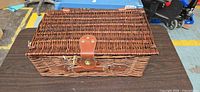 Closed rectangular wicker picnic basket on table