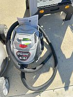 Top view of Shop-Vac showing handle, brand name on handle, attached hose and instruction sheet