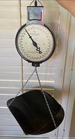 American Family hanging scale with chain and black scoop pan