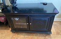 Front view of black TV stand showing two doors and overall design