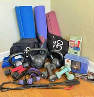 All items grouped: mats, kettlebells, dumbbells, bands, block, headlamp, jump rope