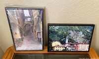 Both framed photographs on display, showing size, frames, and imagery