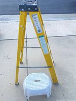 Full view of Keller yellow ladder and white plastic stool