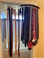 Belts and ties hanging on respective hangers