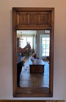 Front view of oak wall mirror showing carved panels and overall condition