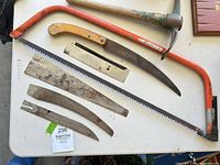 Overview of bow saw, pruning saw, pickaxe, long blade and smaller loose blades