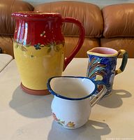 All three pitchers side by side showing relative sizes and designs