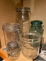Group of five glass canning jars in varying sizes and colors