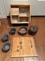 Entire set laid out with teapot, bowls, cups and wooden storage box