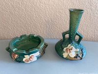 Ashtray and vase front view showing Magnolia pattern and green glaze