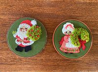 Front view of both round crewel hangings showing Santa and Mrs. Claus designs