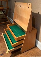 Case closed showing triangular profile, flip lid and two pull-out trays extended