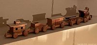 Full view of five-piece wooden train set on ledge